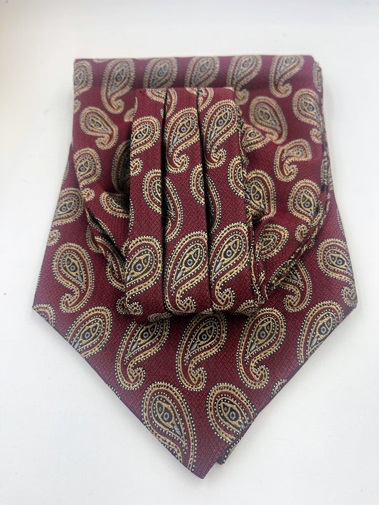 Maroon cravat with gold-coloured paisley patterns folded on a light background.
