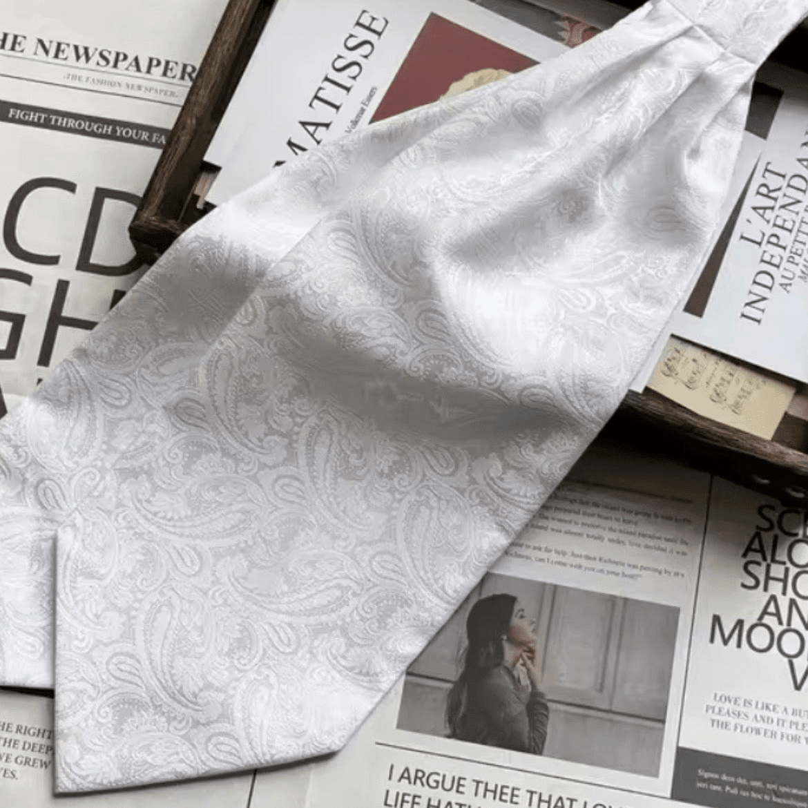 White paisley cravat ascot tie displayed on printed pages.